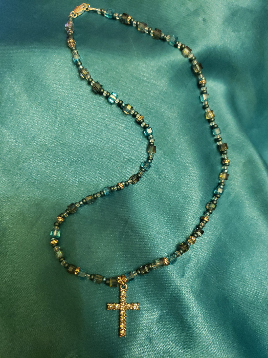 Blue glass bead necklace with crystal cross pendant.